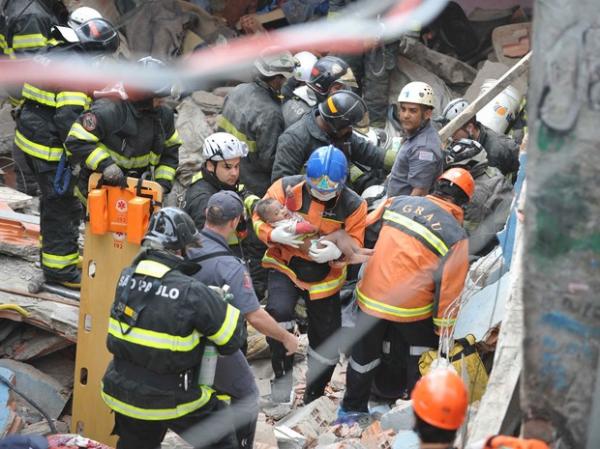 Bombeiros resgatam uma crian&ccedil;a em meio aos escombros.(Imagem:Adriano Lima/Brazil Photo Press/Estad&atilde;o Conte&uacute;do)