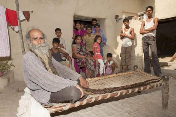 Guru Kailash Singh com amigos e familiares em sua casa.(Imagem:Richard Grange/Barcroft India/Getty Images)
