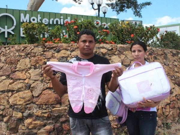 Sildane da Silva com a irm&atilde; mostra parte do enxoval do beb&ecirc;.(Imagem:Gilcilene Ara&uacute;jo/G1)