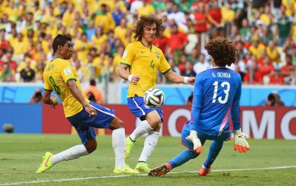 Com os bra&ccedil;os junto ao corpo, Ochoa sai do gol e salva conclus&atilde;o de Paulinho.(Imagem:Getty Images)