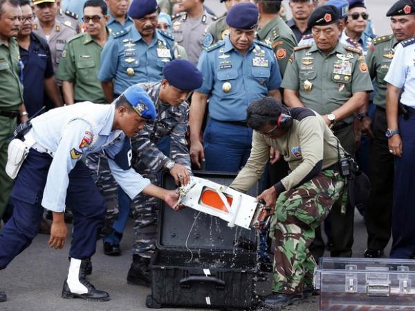 Caixa-preta do voo da AirAsia QZ8501 &eacute; transferida para um compartimento transparente ap&oacute;s chegar &agrave; base a&eacute;rea de Pangkalan Bun, na Indon&eacute;sia. O equipamento foi encontrado por merg(Imagem:Darren Whiteside/Reuters)