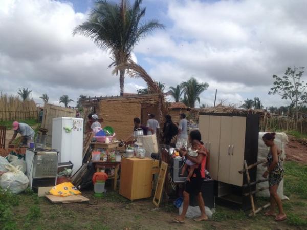 Fam&iacute;lias retiram os pertences de dentro das casas. (Imagem: Gil Oliveira/G1)