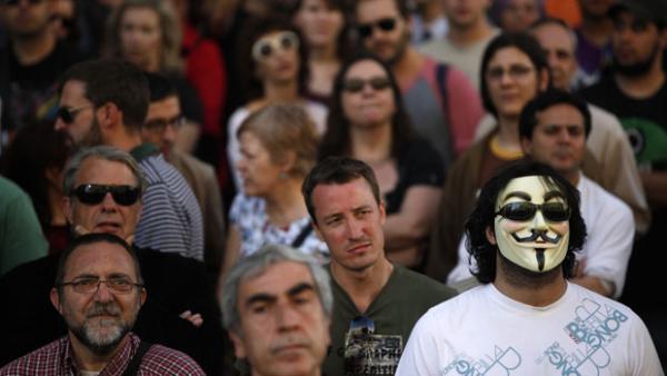 Durante o movimento ?Democracia Real Agora?, em Madri (Espanha), uma pessoa &eacute; vista com uma m&aacute;scara de Guy Fawkes, de 'V de Vinga&ccedil;a' usada por membros do grupo de hackers Anonymous(Imagem:Susana Vera/Reuters)